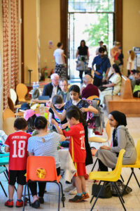 The barber foyer filled with tables, colourful chairs with families sitting on them
