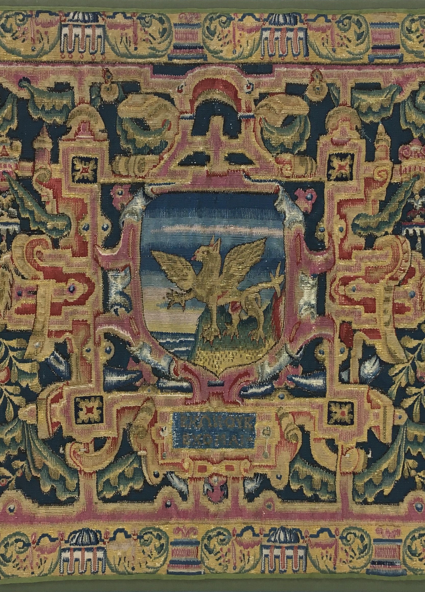 Ornate tapestry with a griffin in the centre and patterns surrounding