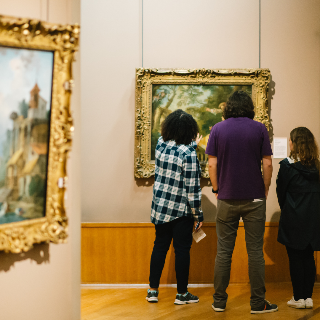 Three people looking at an artwork